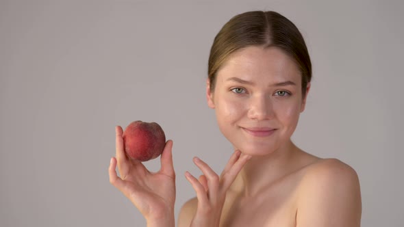 Beautiful girl holding apple smiling and enjoying natural skin care