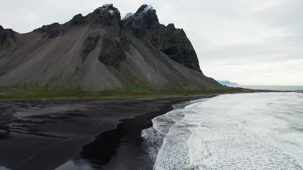 Drone Pulling Back Over Sea Black Sand Beach And Vestrahorn alt
