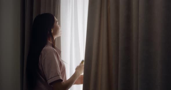Woman Pushes the Curtains in the Bedroom and Vapes