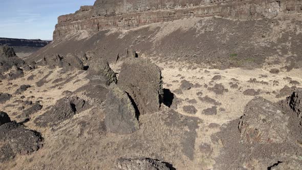 Ancient weathered basalt columns scattered on a desert canyon, Dry Lake Falls, Washington, aerial or alt