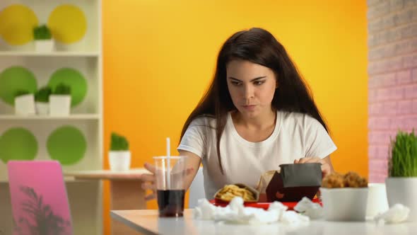 Female Cafe Customer Biting Tasteless Burger Drinking Soda Water, Cheap Food alt