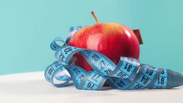 Red Apple with Tape Measure Rotate on Blue Background