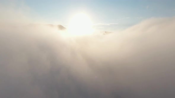 Thick clouds on background of mountain tops alt