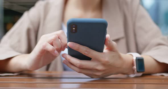 Woman use of mobile phone in outdoor restaurant alt