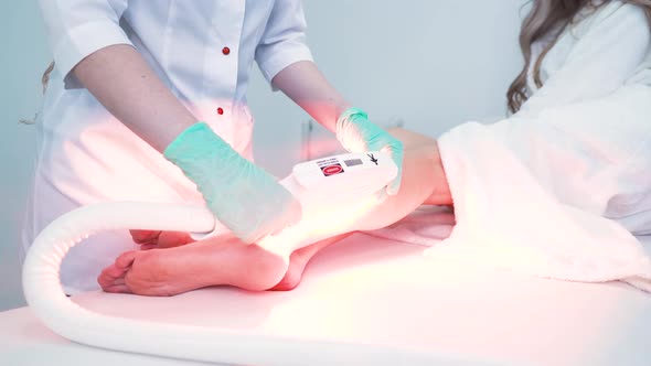 Dermatologist in Gloves Does Laser Epilation in Clinic alt
