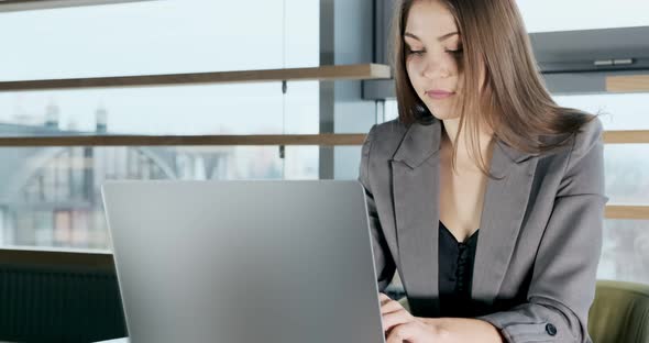 Concerned Woman Working on Laptop Computer and Looking Away Thinking Solving Problem at Office alt