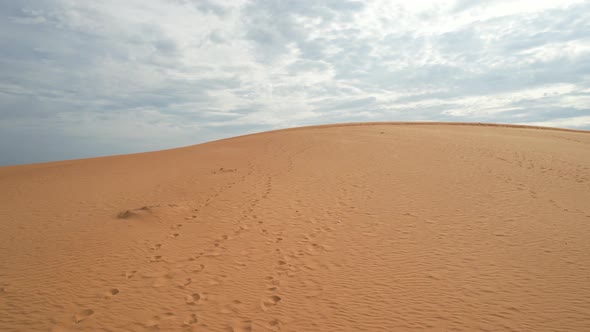 low aerial flying above the top of a desert sand dune in Mui Ne Vietnam alt