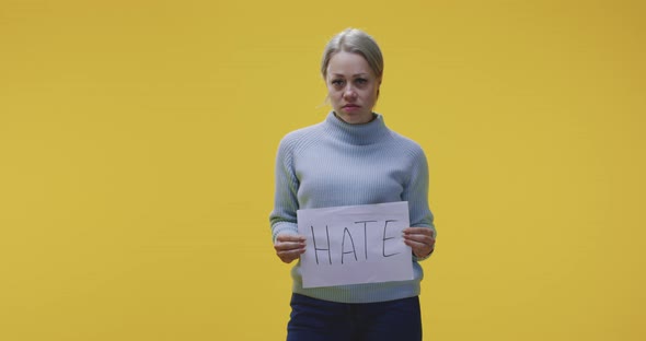 Woman Holding Hate Sign alt