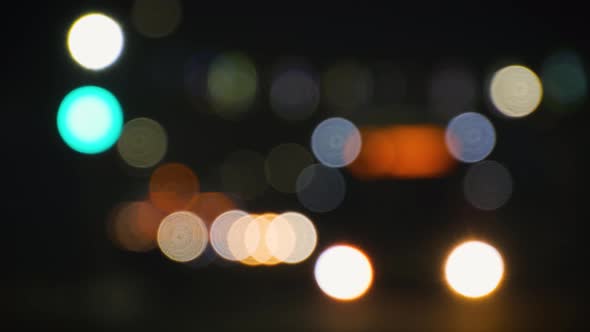 Blurred Headlights of Moving Cars and Traffic Lights in the City at Night alt