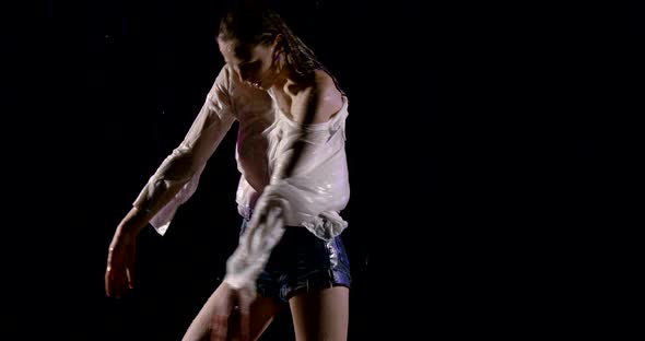 Beautiful Sexy Girl in White Shirt with Open Shoulder and Short Shorts. She Stands on a Black alt