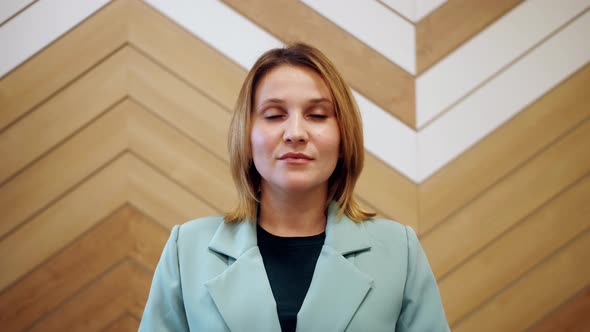 Confident smiling young adult european woman looking at camera standing at home office. alt
