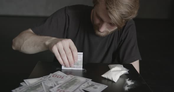 Young Addicted Man Taking Cocaine with Dollar alt