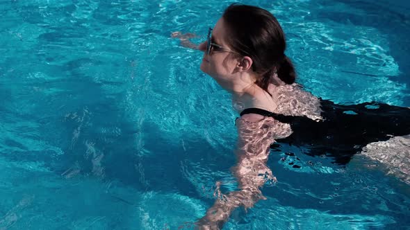 Close Up of an Young Woman Swimming in Above Ground Pool