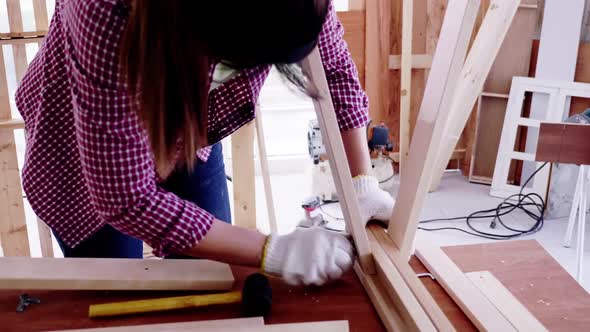Woodwork and furniture making concept. Stylish craftswoman working in carpentry alt