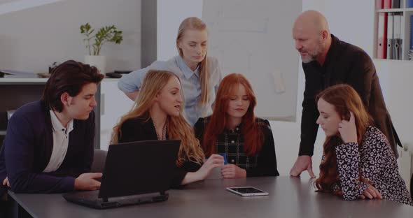 Male and Female Colleagues Discussing Over Tablet PC alt