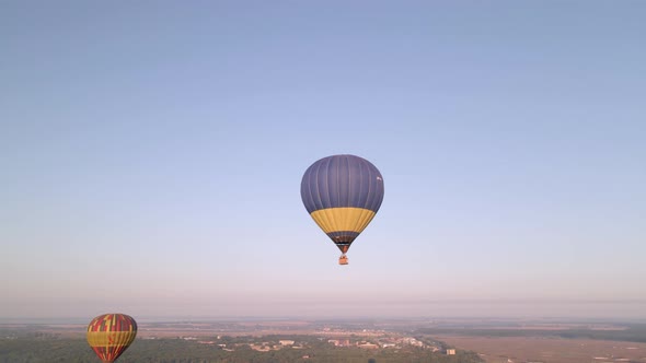 Colorful Hot Air Balloons Flying Over Green Park in Small European City at Summer Sunrise, Aerial alt