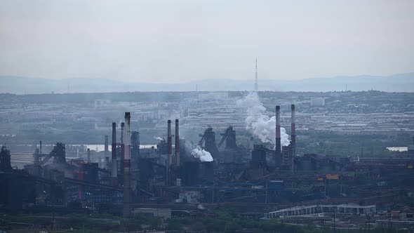 Time Lapse of Working Factory Producing Air Pollution Against the City