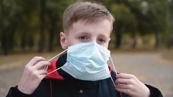 Child Boy Putting on Medical Mask for Coronavirus Prevention.