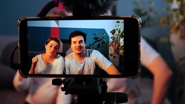 Closeup of Smartphone Standing on a Shoot and Filming an Interview of Young Man and Woman alt