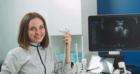 Close Up Portrait of Professional Smiling Young Woman Doctor Sonographer Sitting alt