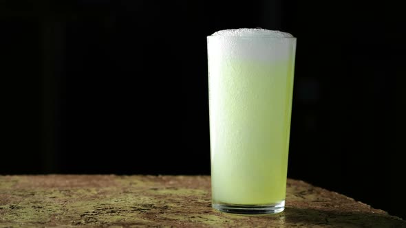 Carbonated Drink, Yellow in Color and Poured Into a Glass on a Black Background.