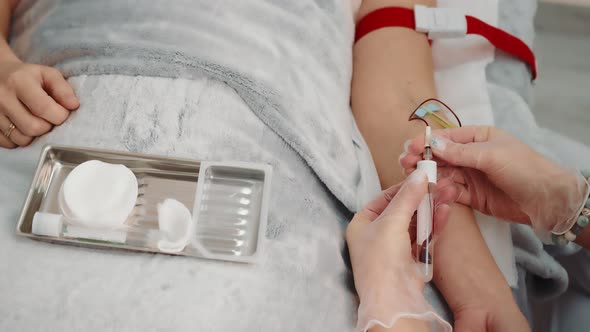Nurse Taking a Blood Sample From a Patient Lying in a Hospital Ward alt
