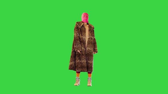 Young Girl in Pink Balaclava and Leopard Coat Dancing Slightly on a Green Screen Chroma Key