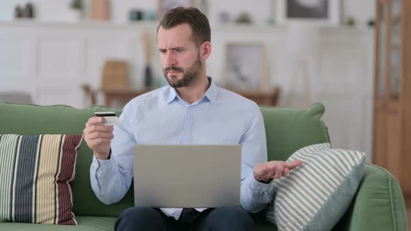 Online Shopping Failure on Laptop for Young Man on Sofa alt