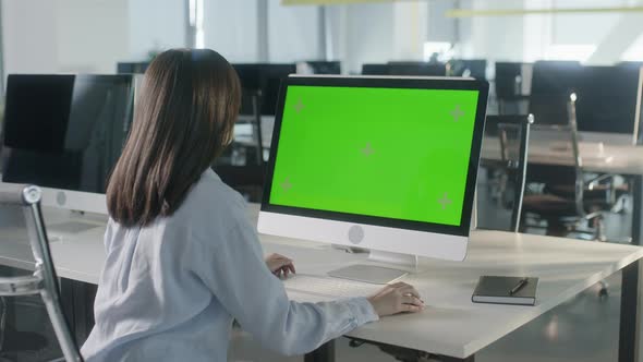 Business Multiethnic Woman Working on Desktop Computer with Green Screen Mock Up Display in Busy alt