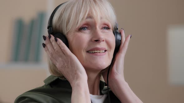 Portrait Happy Relaxed Blonde 60s Grandmother Dancing Old Caucasian Woman in Headphones Carefree alt