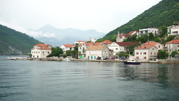 View From the Ferry to the Houses on the Coast Against the Backdrop of Mountains alt