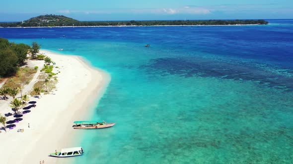 Large coral reefs seen through clear water of turquoise lagoon surrounding white sandy beaches of tr alt