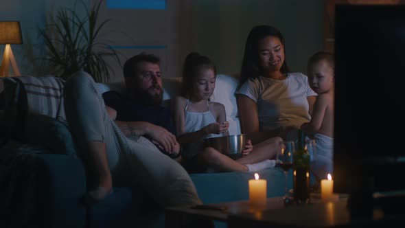 Diverse Family Watching Movie in Dark Living Room alt