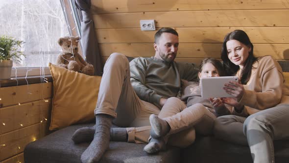 Cheerful Family of Three Using Tablet in Cabin alt