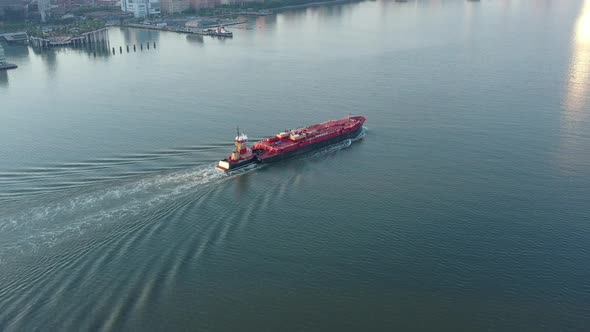 An aerial view over the Hudson River with Manhattan's westside in view at sunrise. The sun reflects alt