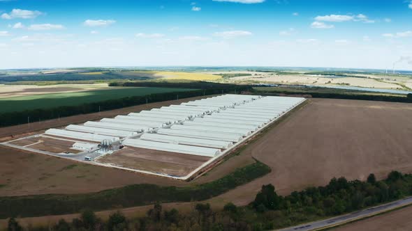 Modern factory among nature. Exterior of a large modern production plant.  alt