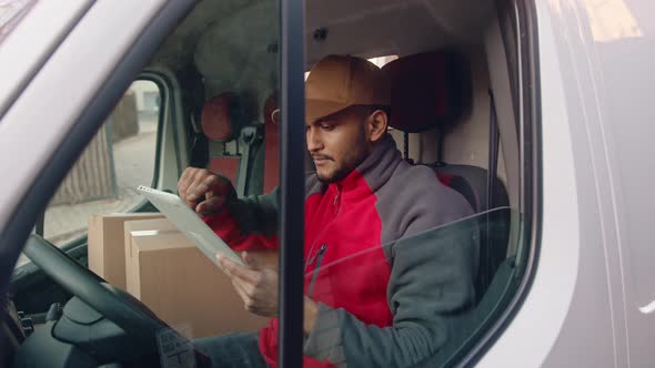 Young Indian Man Courier Using Tablet While Delivering Parcel alt