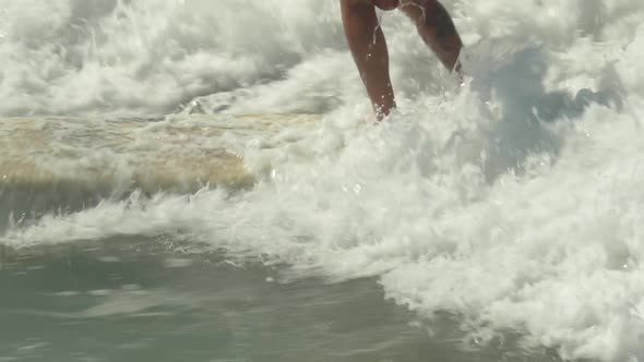 A male surfer rides a wave on a longboard surfboard. alt