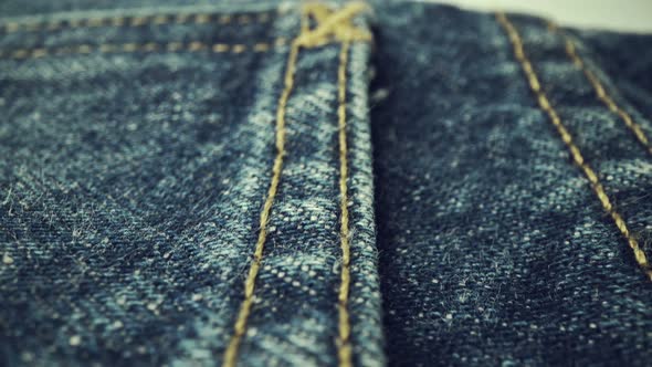 Extreme detailed of blue denim jeans texture in dolly shot over cloth surface. alt