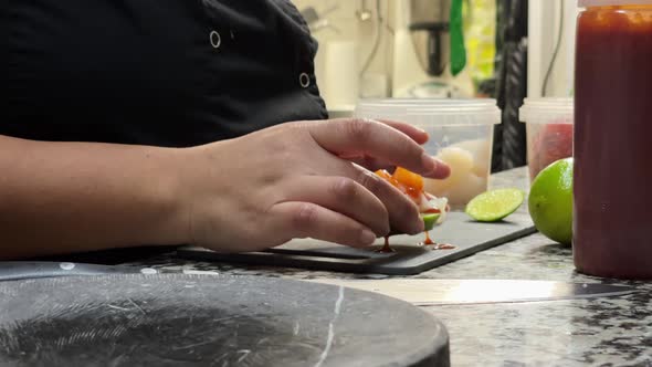 Professional cooker presents ceviche in dark stone plate alt