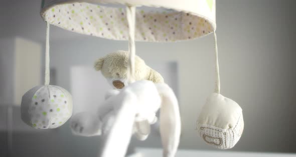 Baby Mobile with Different Animals Hanging Over the Child Crib of a Newborn
