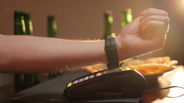 Customer Paying With NFC Technology by Smart Watch Contactless on Terminal in Modern Cafe 
