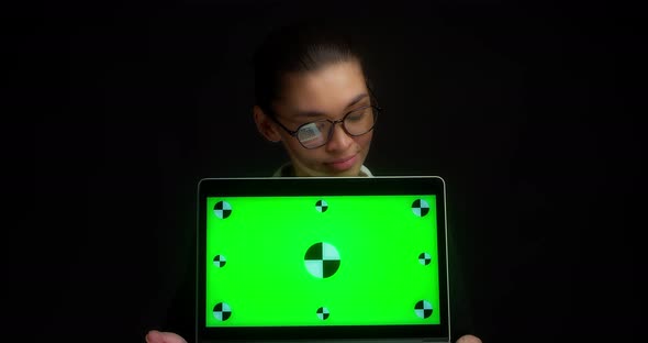 Woman Holds a Green Laptop Screen and Shows No with Her Head
