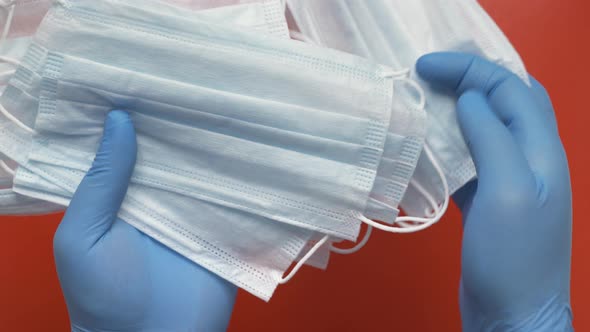 Paramedic Showing Antiviral Face Mask Holding Equipment in Hands Protected by Blue Medical Gloves