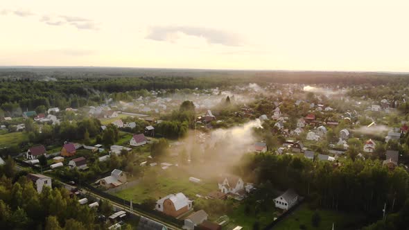 Aerial Shot of Beautiful Countryside Village in the Morning Sunlight, with Mist Floating on the Farm alt