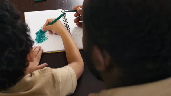 African American child scribbling with felt pen in notebook