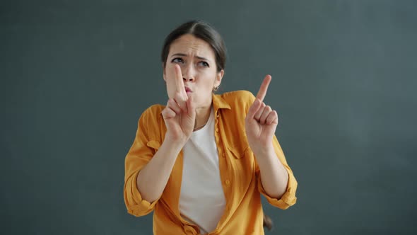 Slow Motion Portrait of Young Woman Dancing and Singing Having Fun on Gray Background alt