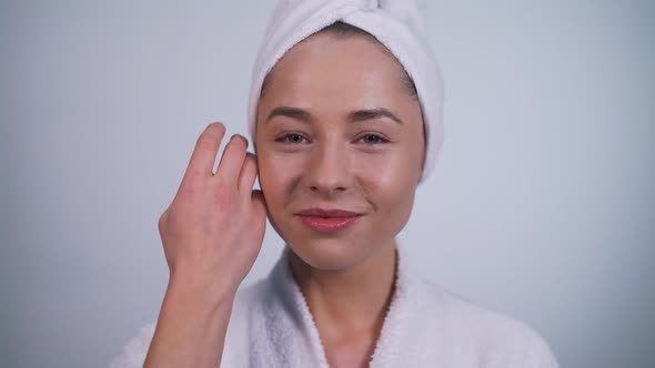 Girl in a Bathrobe Touches Her Face Close-up