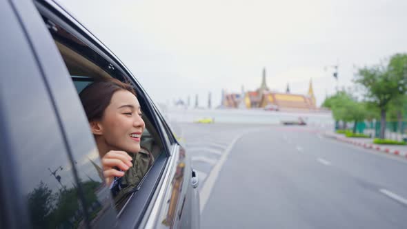 Asian beautiful woman traveler open car window to face air outside. alt