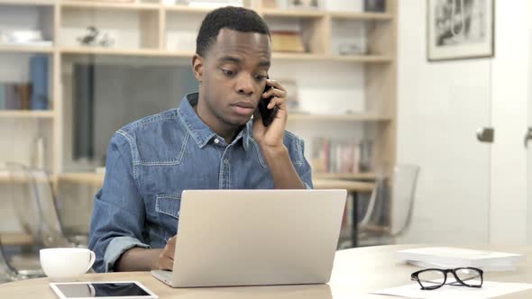 AfroAmerican Designer Talking on Phone Discussing Work alt